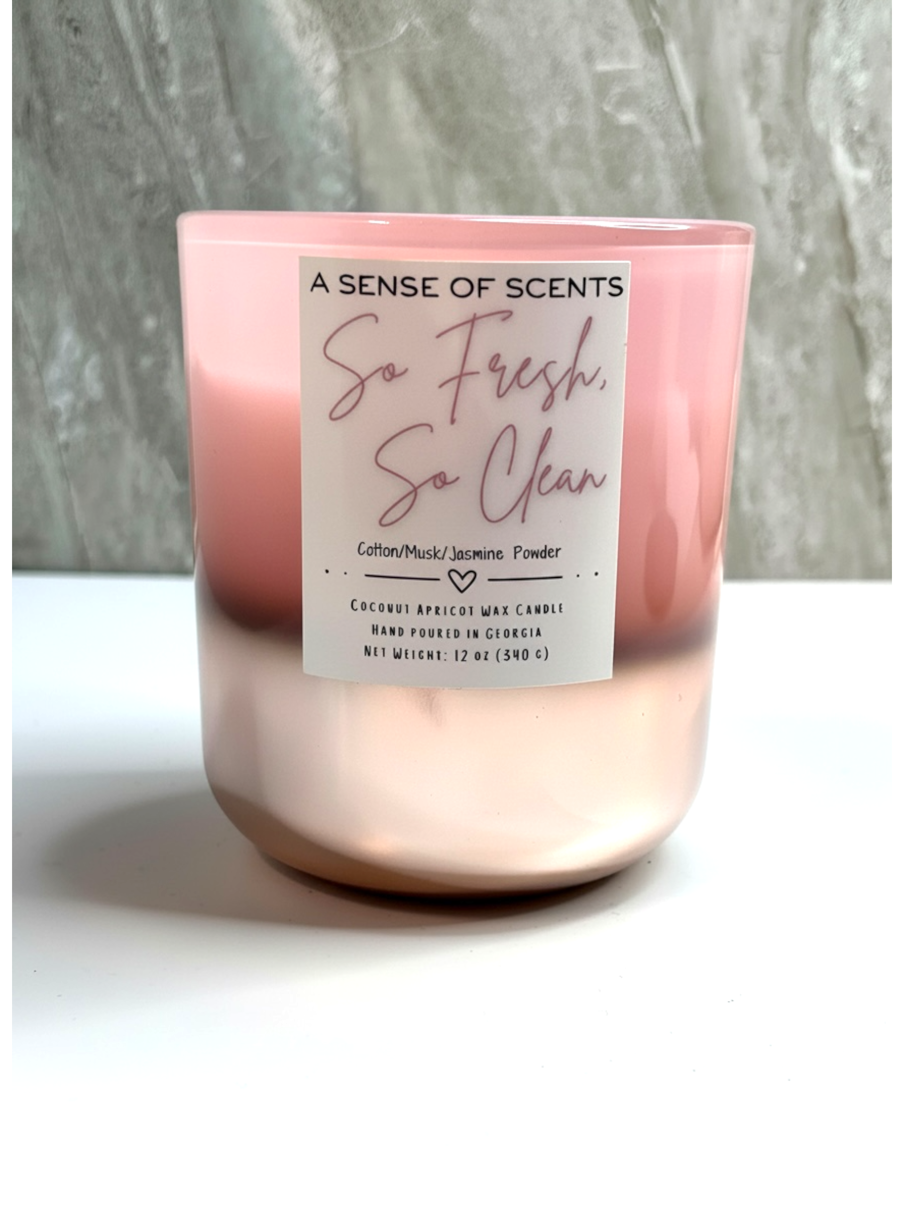 Pink candle labeled so fresh so clean on a white surface