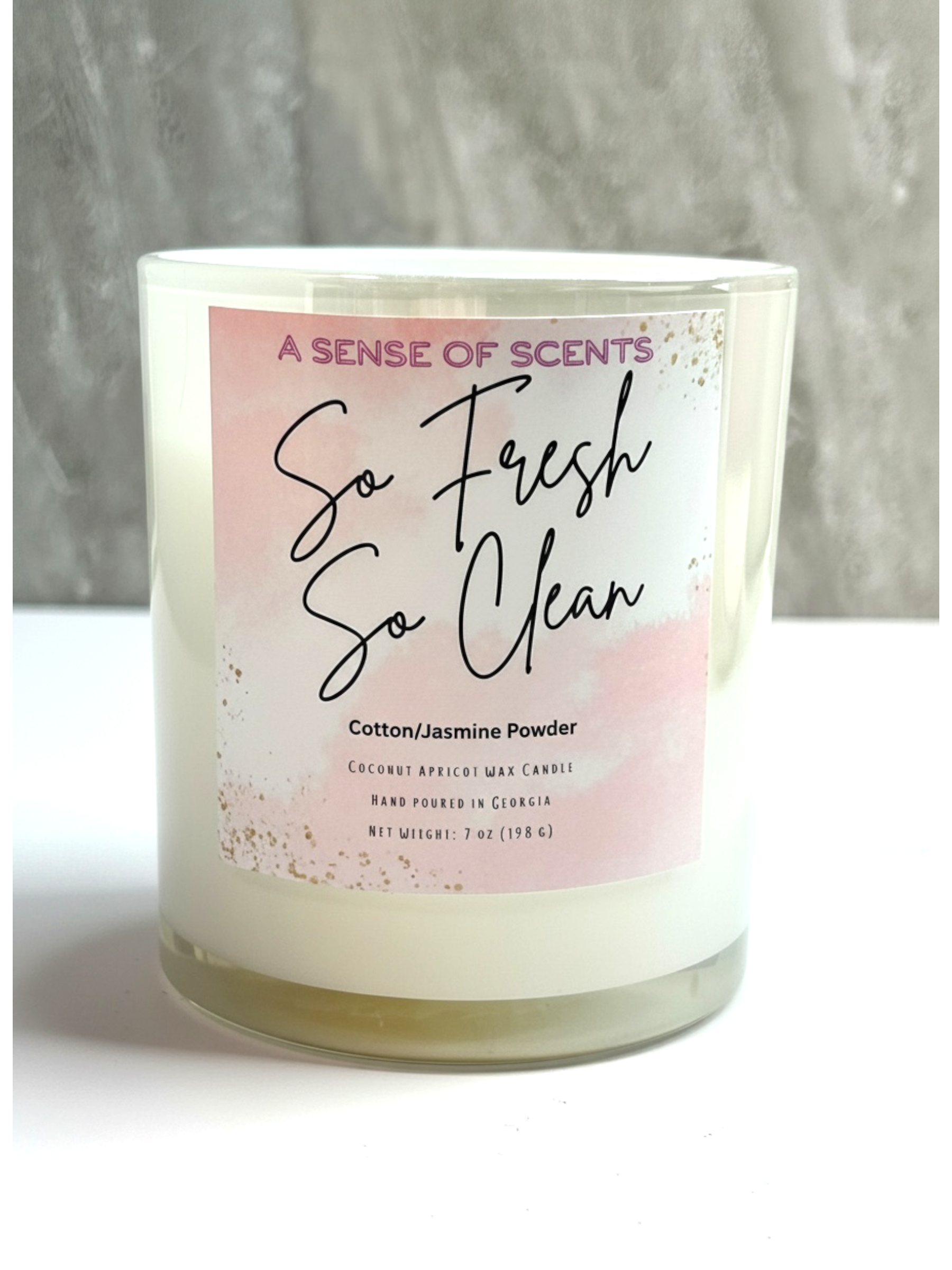 Candle with a label reading 'So Fresh So Clean' by A Sense of Scents on a neutral background.