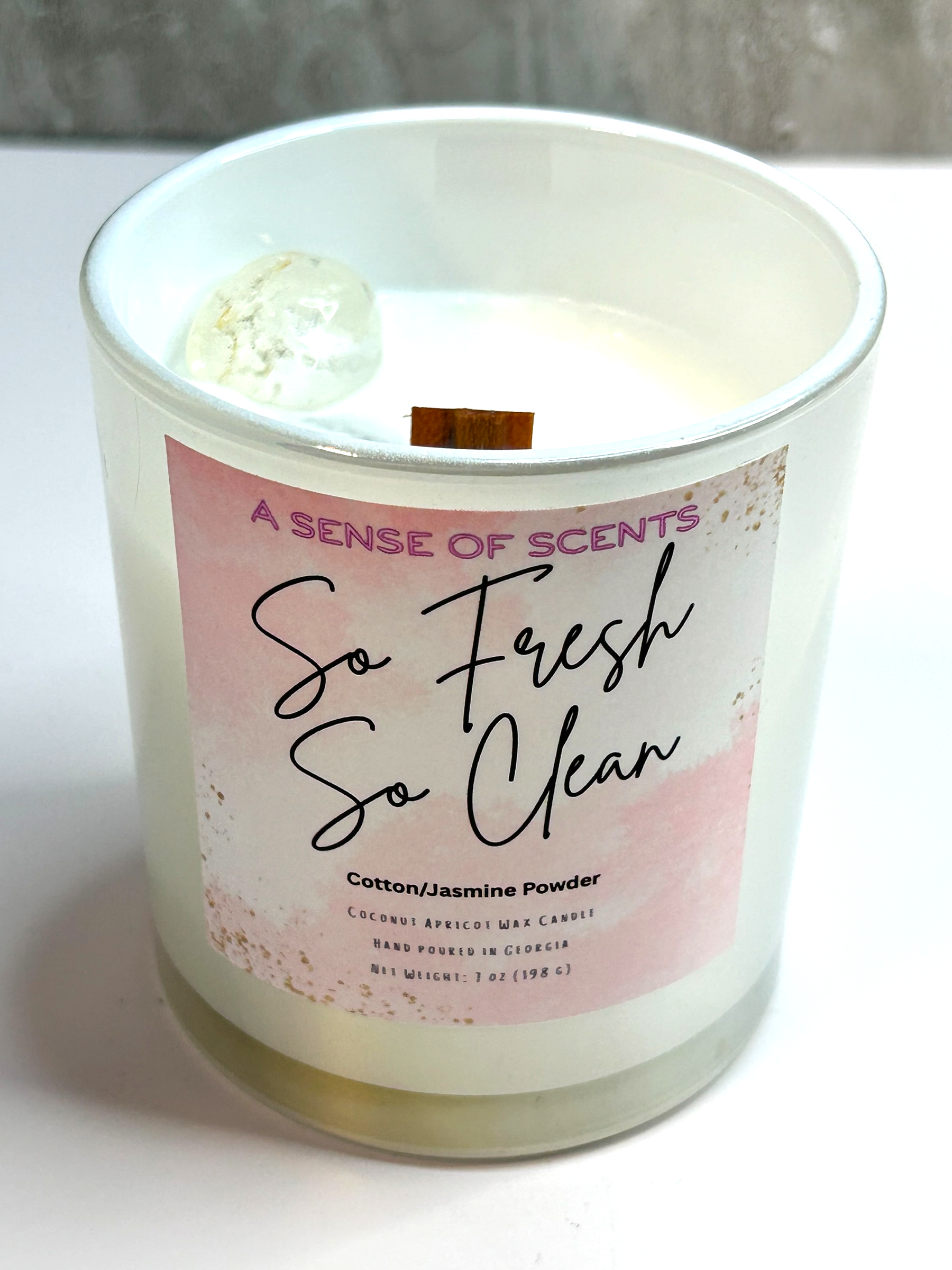 Candle with a 'So Fresh So Clean' label on a white surface