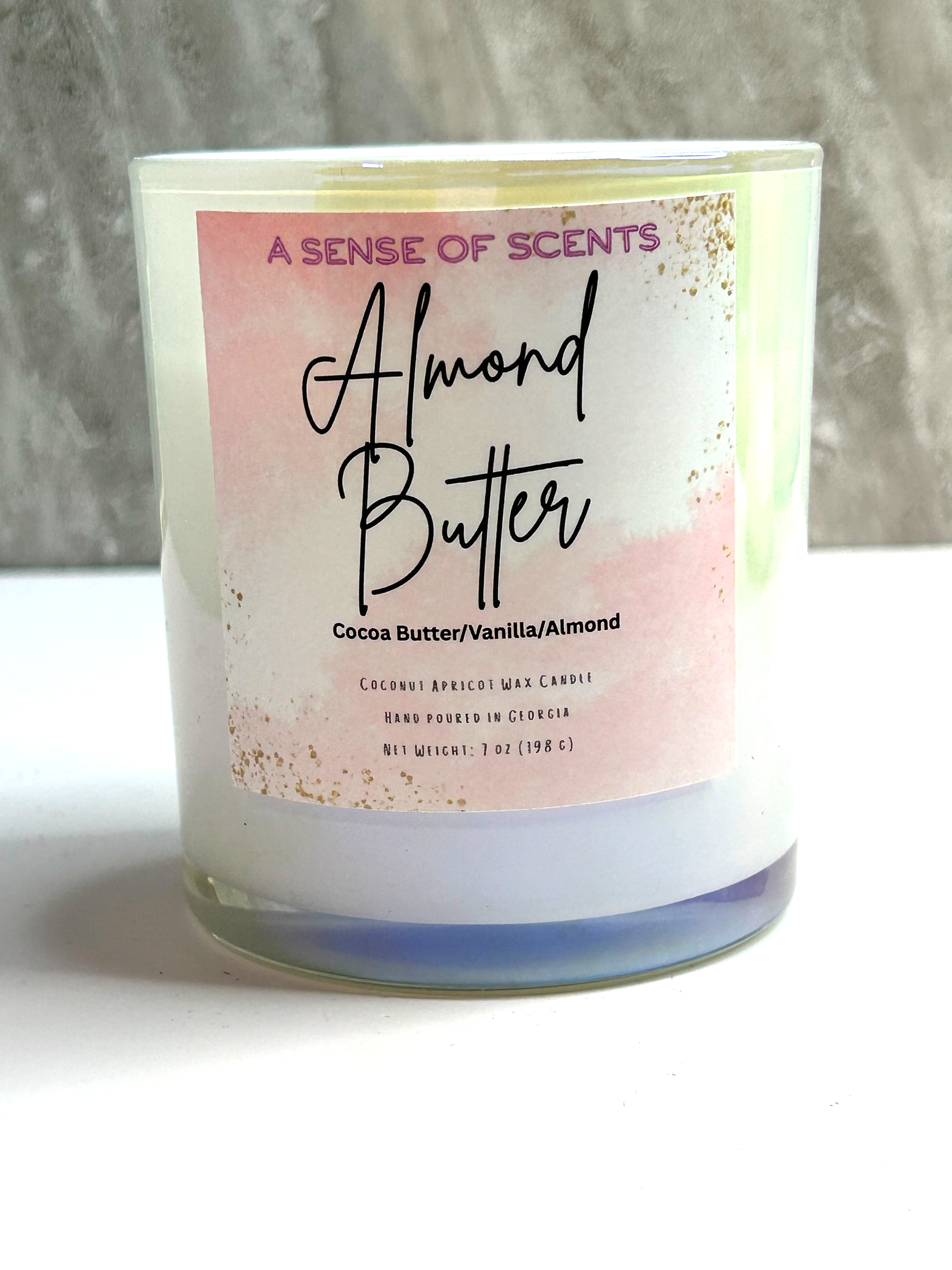 Candle with 'Almond Butter' label on a white surface