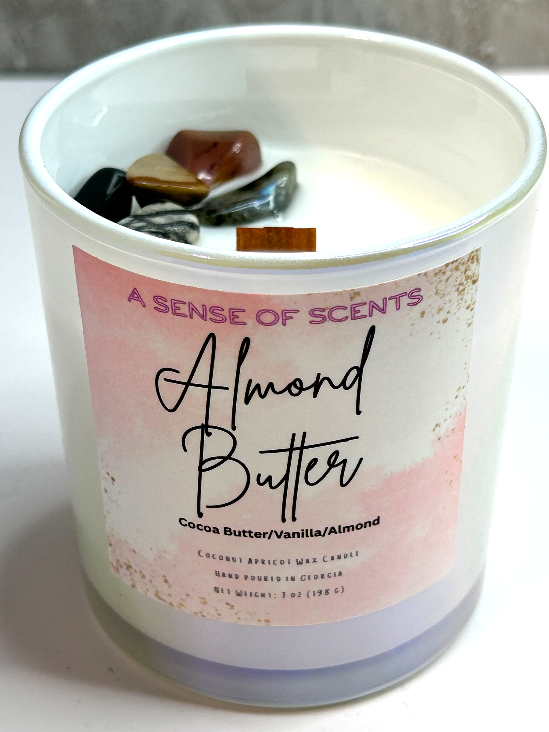 Candle with 'Almond Butter' label on a white surface