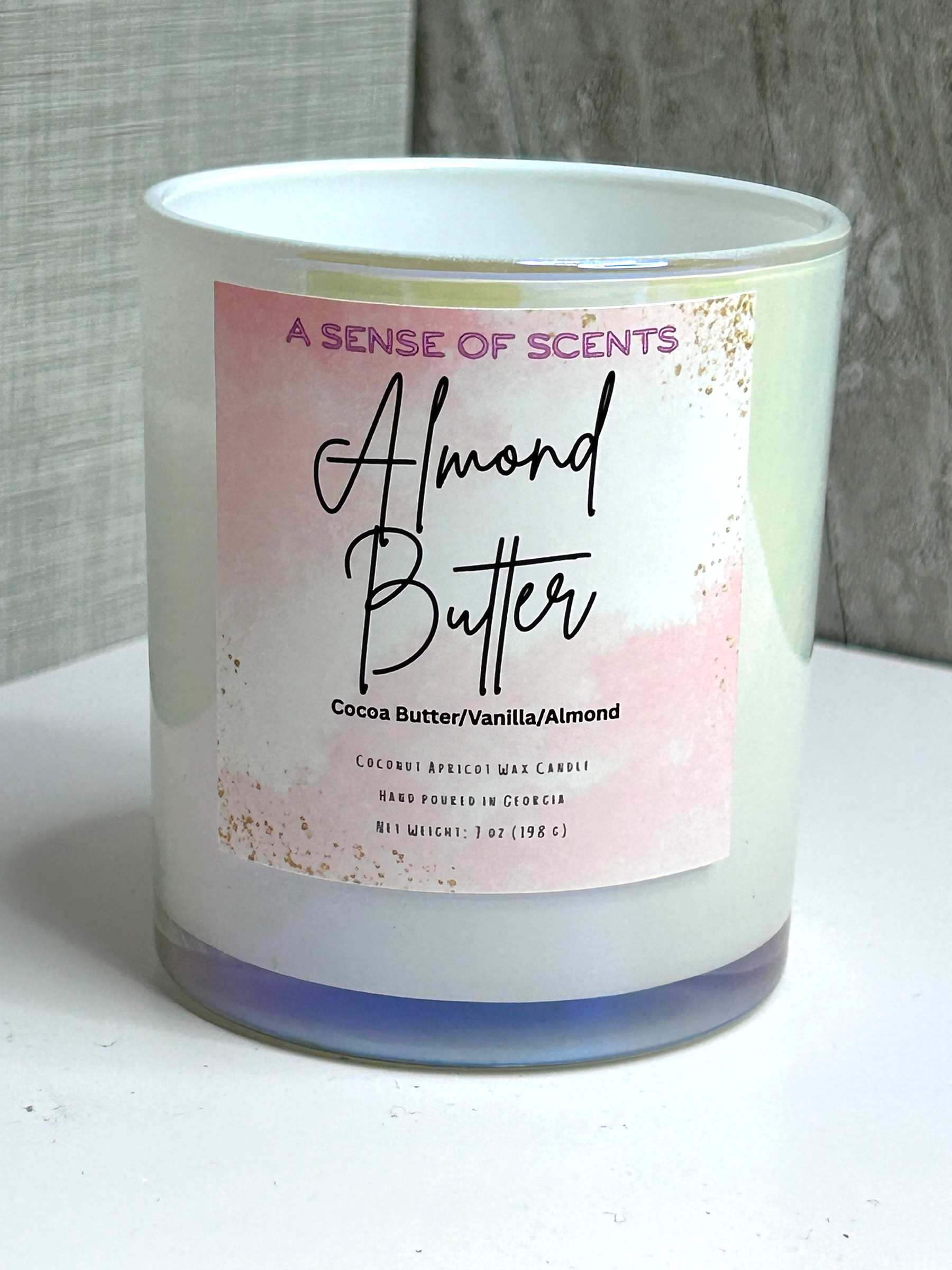 Candle with 'Almond Butter' label on a white surface
