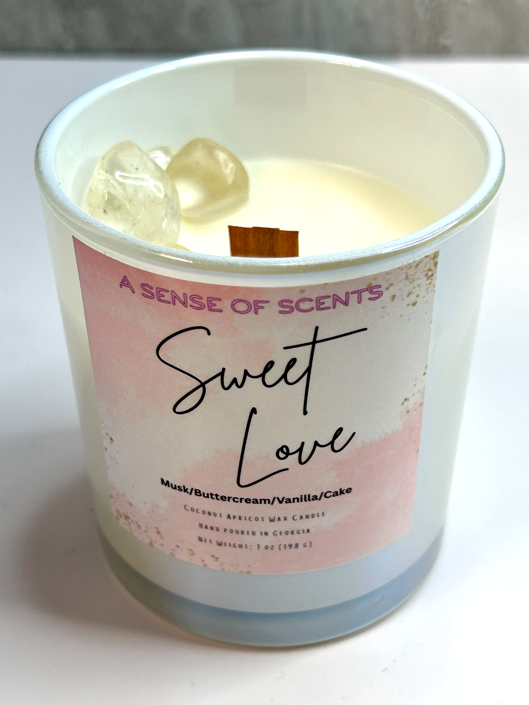 Candle in a glass jar with a 'Sweet Love' label on a white background