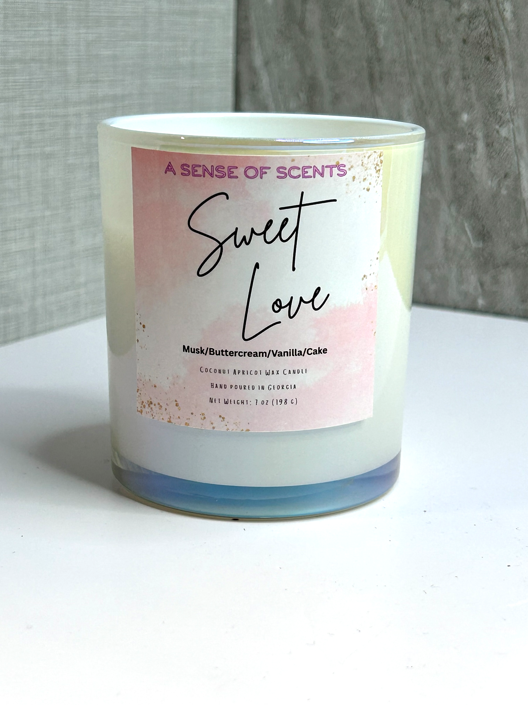 Candle with 'Sweet Love' label on a white surface