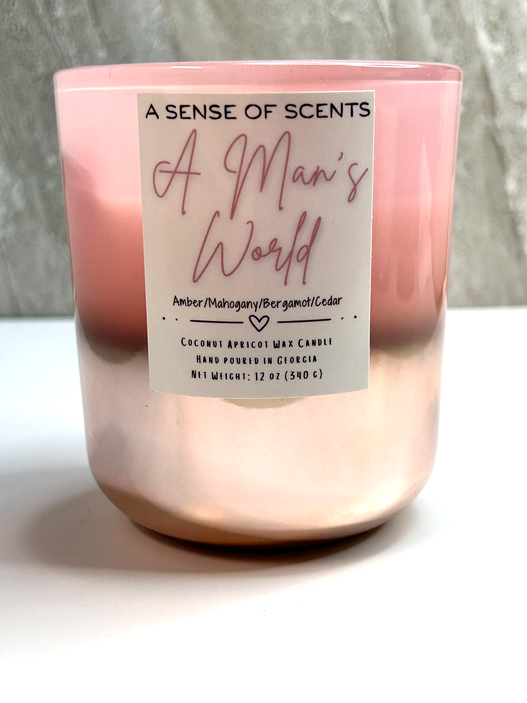 Pink candle labeled 'A man's world' on a white background