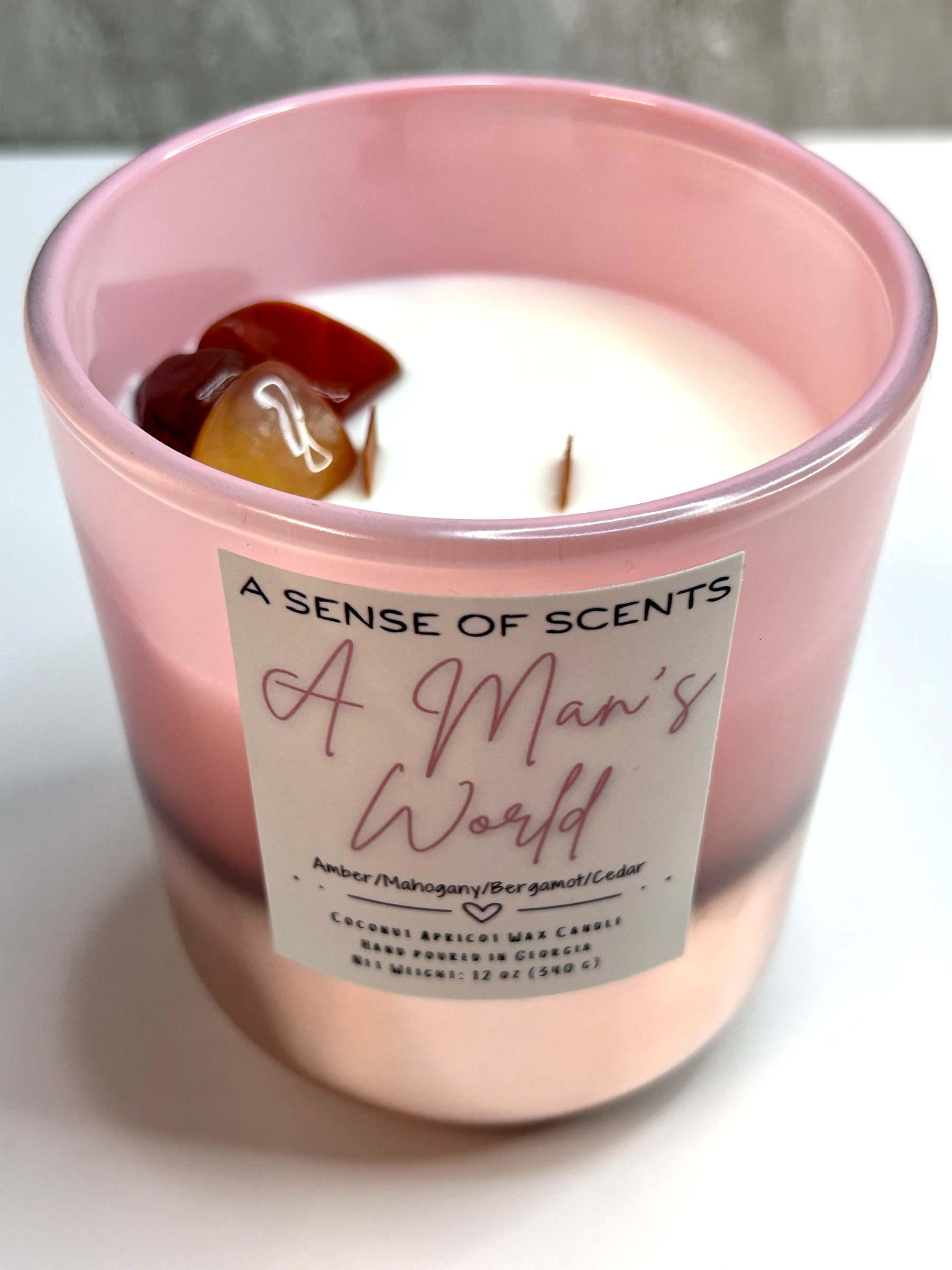 Pink candle labeled 'A man's world' on a white background