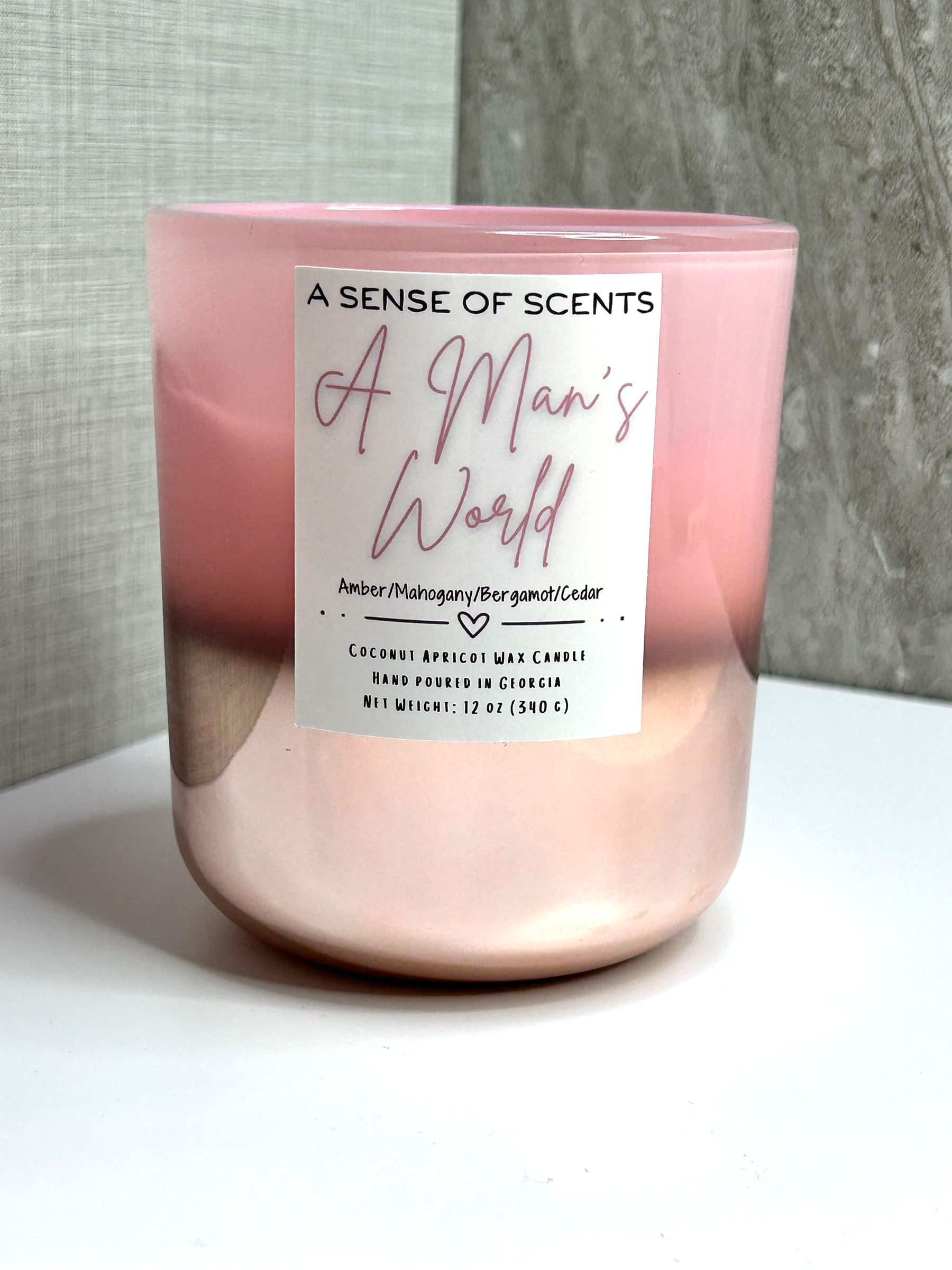 Pink candle labeled 'A man's world' on a white background
