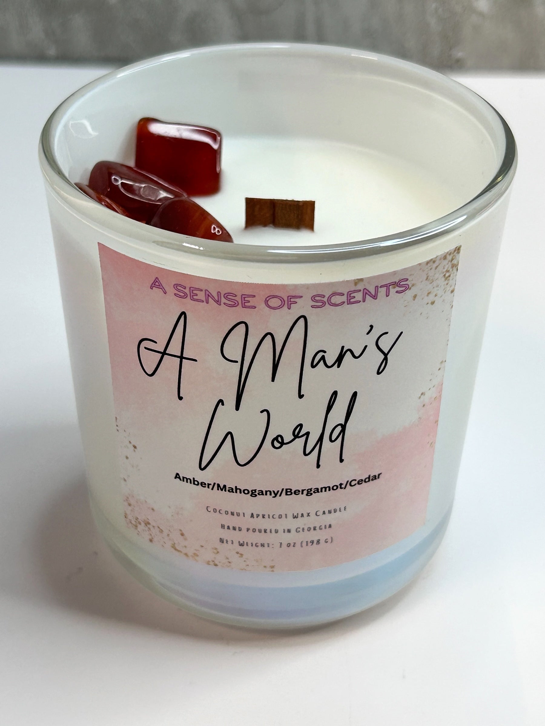 Candle with a label reading 'A Man's World' on a white surface