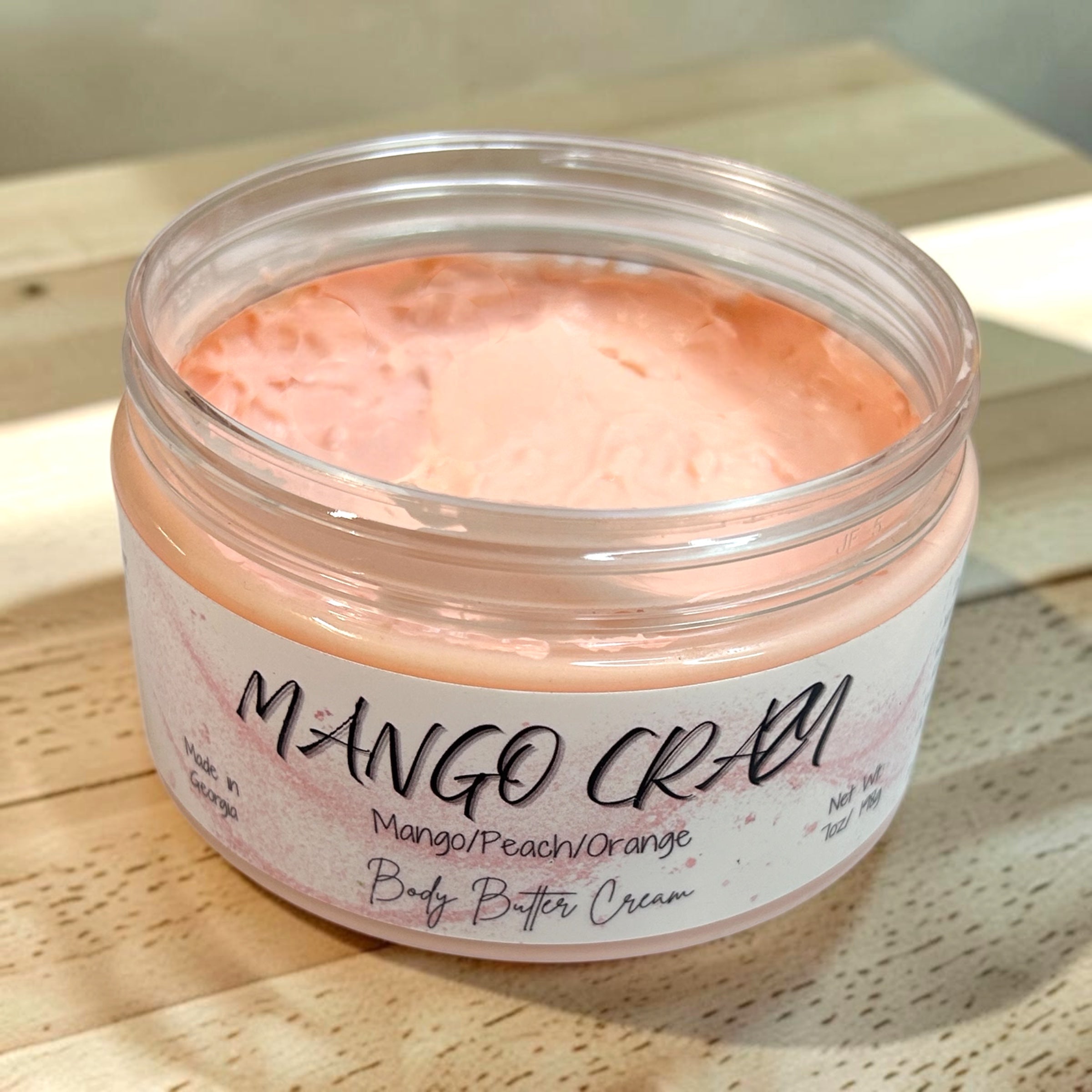 Jar of Mango Cream body butter cream on a wooden surface