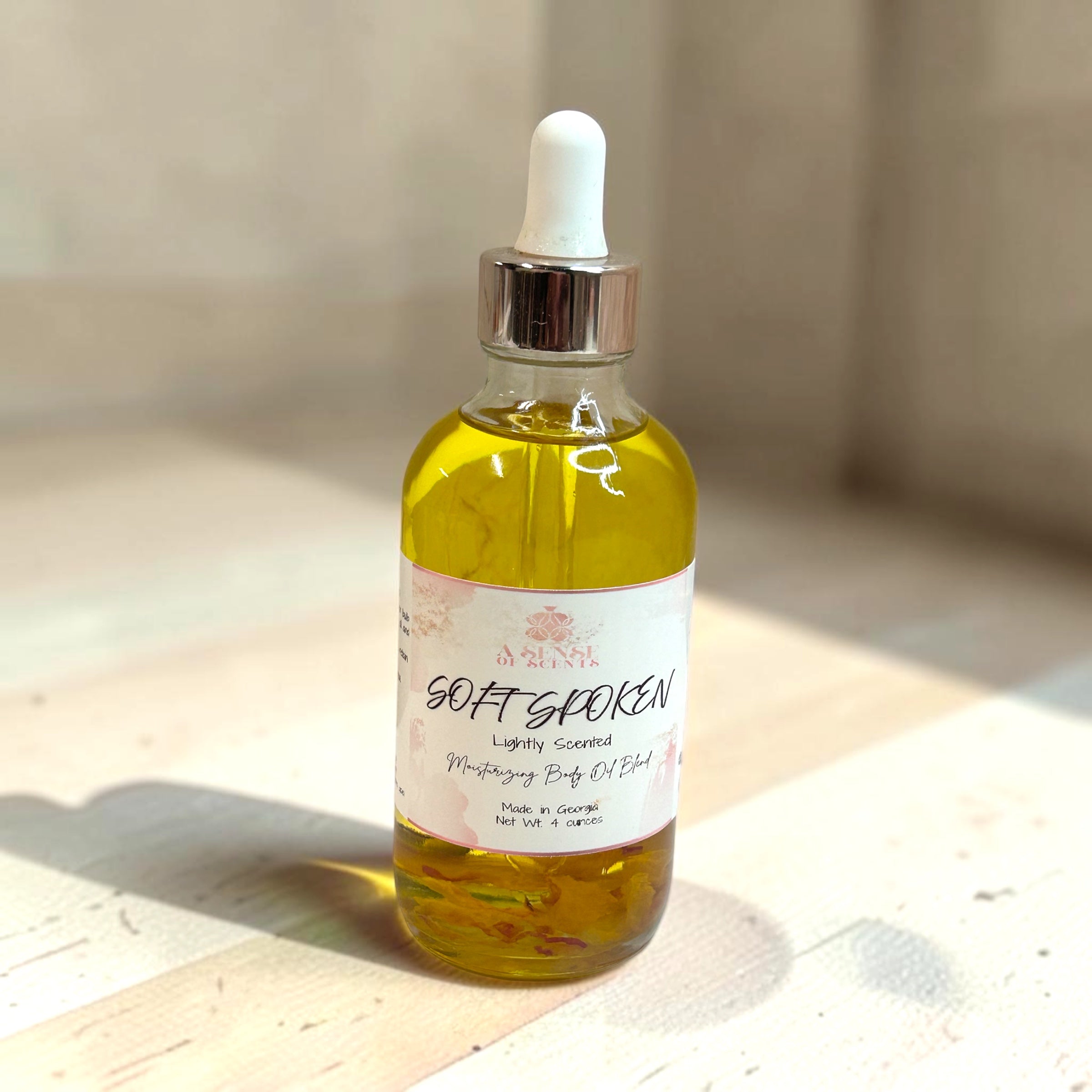 Bottle of 'Soft Spoken' oil with a dropper on a wooden surface