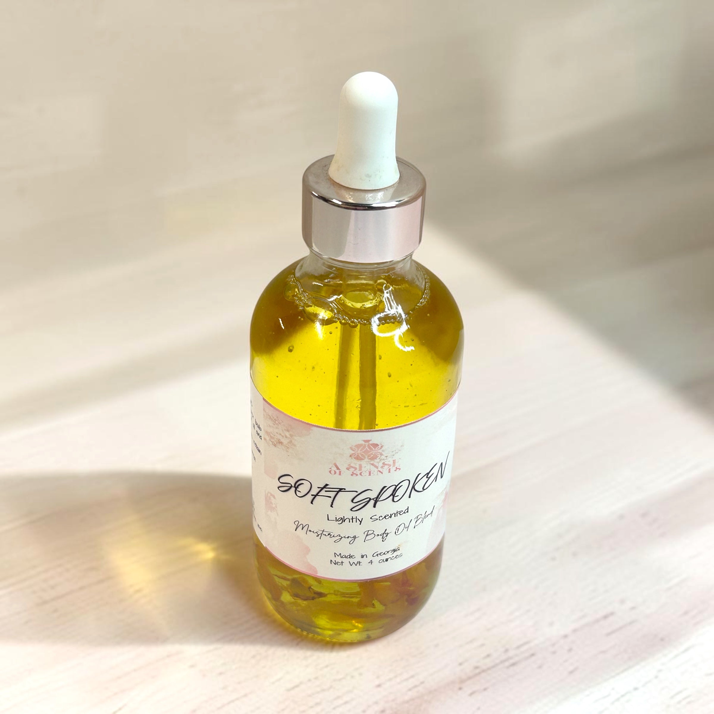 Bottle of 'Soft Spoken' oil with a dropper on a wooden surface