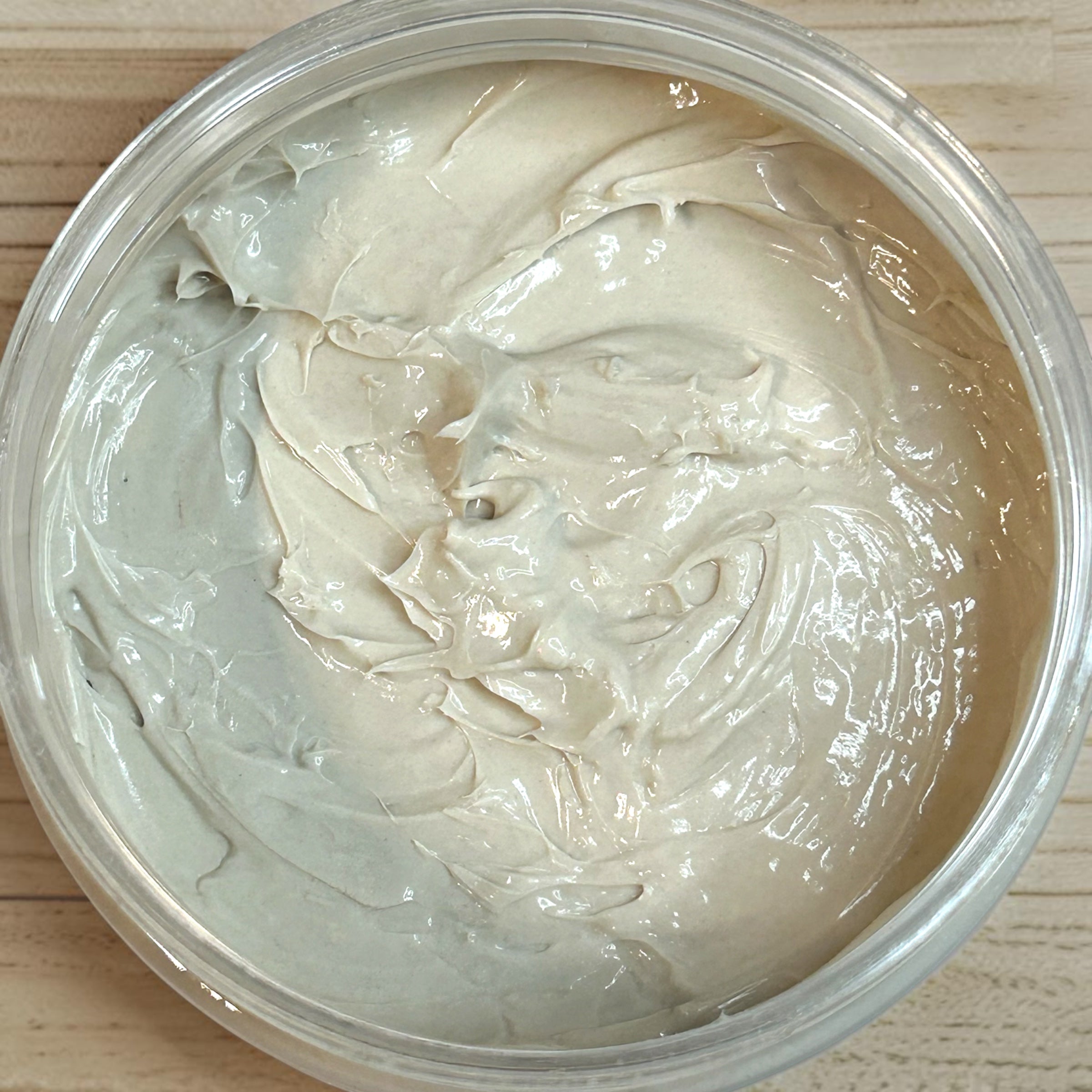 Close-up of a container of white cream on a wooden surface