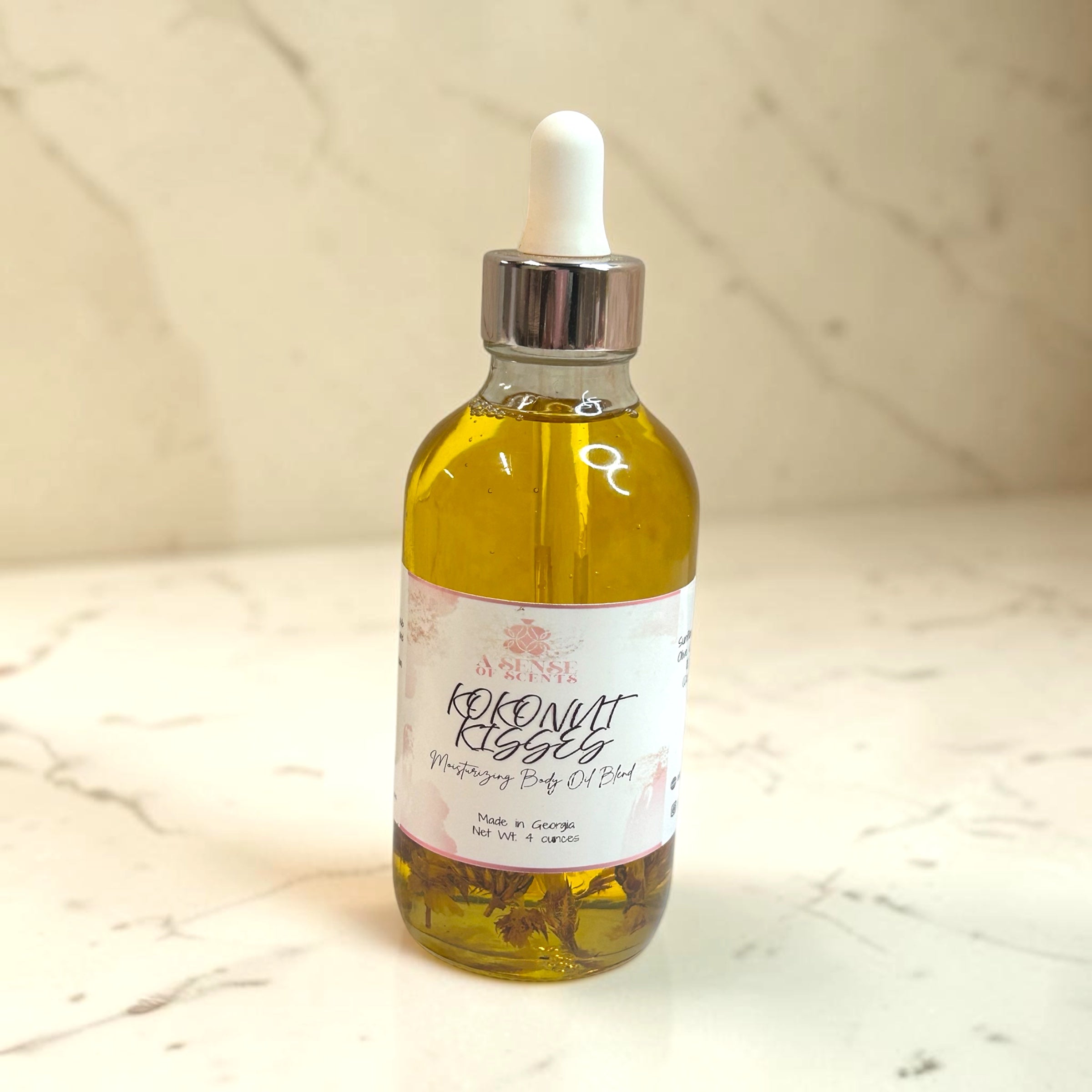 Bottle of coconut oil with a dropper on a marble surface